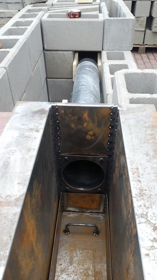 Detailní pohled na instalaci kovového komína do zděné udírny.