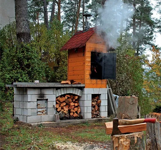 Dokončená udírna postavená vlastními rukama s dřevem a nástroji.