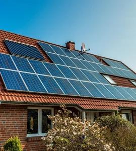 Fotovoltaické střešní tašky na domě s červenou střechou.