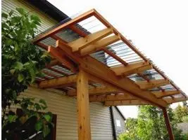 Dřevěná pergola s průsvitnou střešní krytinou na domě.