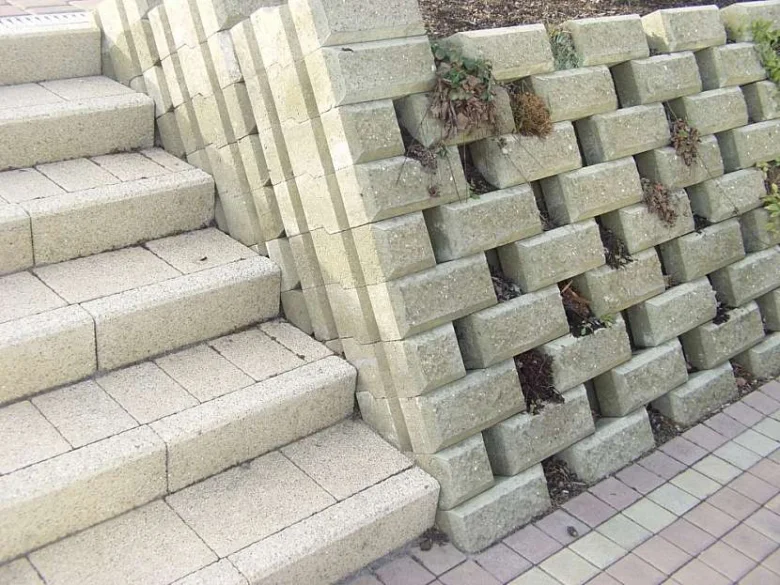 Schody ze zámkové dlažby vedle zdi s bloky.
