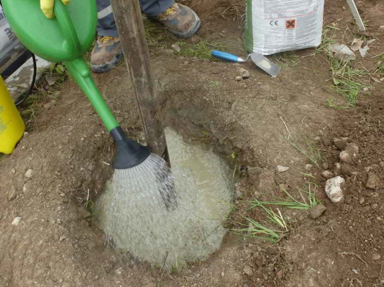 Nalévání rychle tuhnoucího betonu do jámy pro sloup.