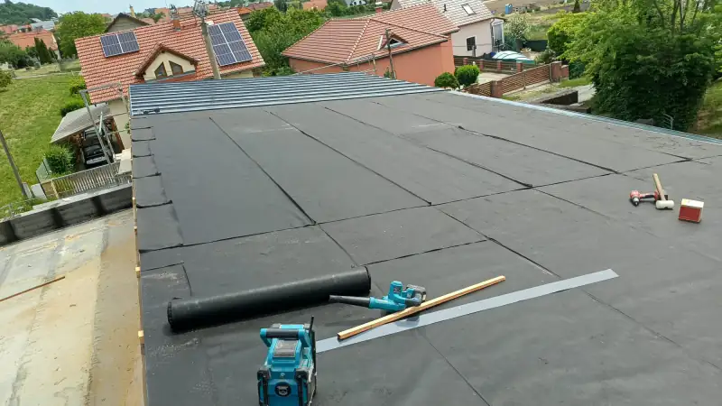 Montáž hydroizolace na střechu s klempířskými nástroji v Brně.