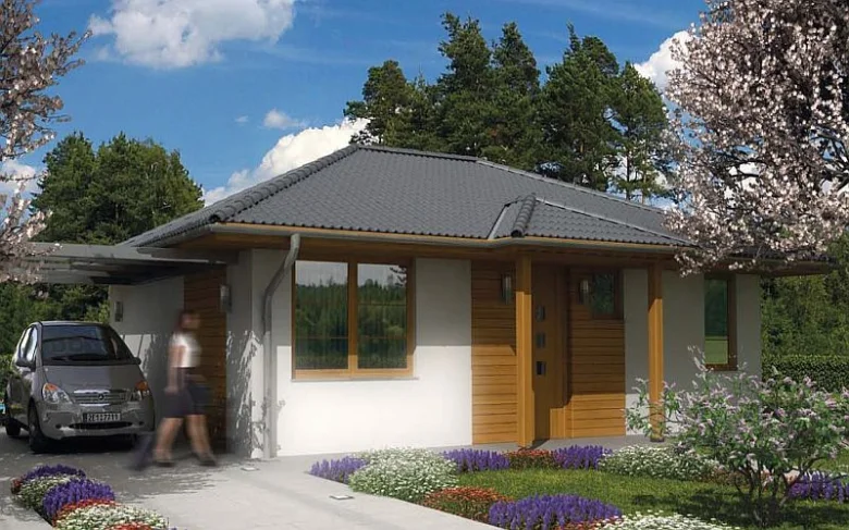 Moderní dřevostavba s šedou střechou v kvetoucím zahradním prostředí.