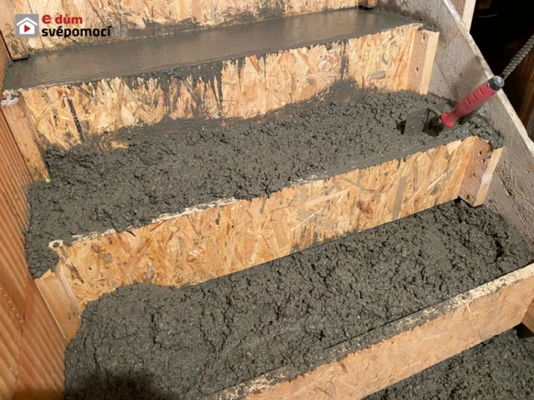 Zvlhčený beton se nalévá na dřevěné bednění pro stavbu schodiště.