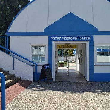 Vstup do venkovního bazénu v Novém Jičíně s modrým nápisem.