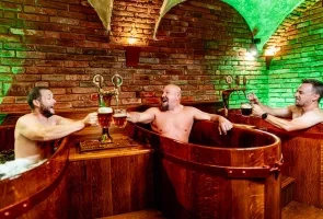 Muži v dřevěných lázních s horkou vodou.