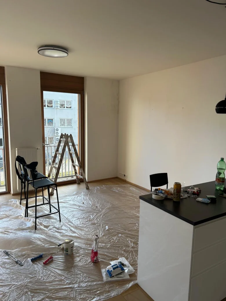Pracovní prostor pro malování bytu v Praze s ochrannou fólií a nářadím.
