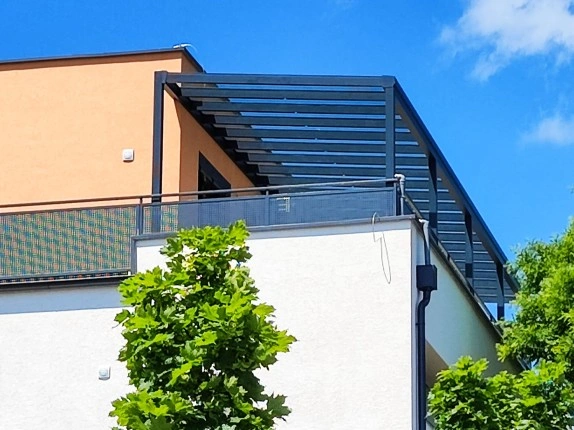 Moderní hliníková pergola s lamelami na balkóně domu.