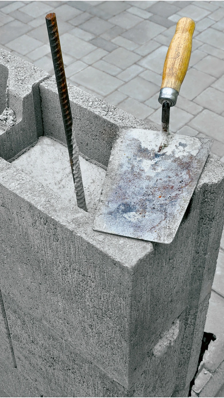 betonový blok s výztuží a špachtlí na stavbě
