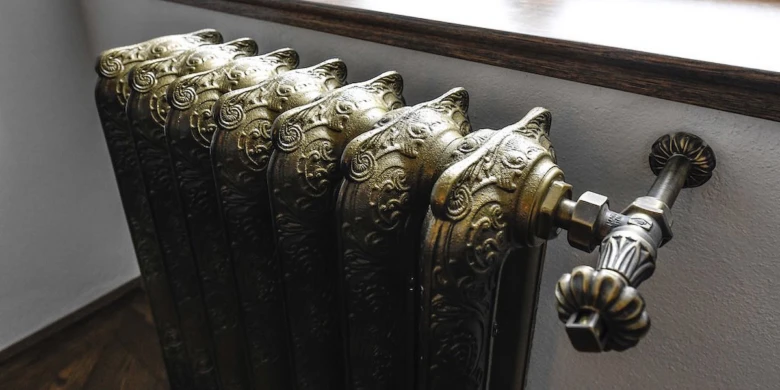 Detail starého litinového radiátoru s ozdobným povrchem.