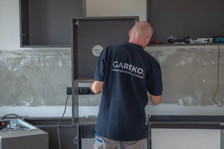 Montáž kuchyně na míru: dělník montuje skříňovou konstrukci.