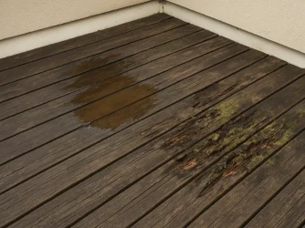 Znečištěná dřevěná terasa s plesní v rohu
