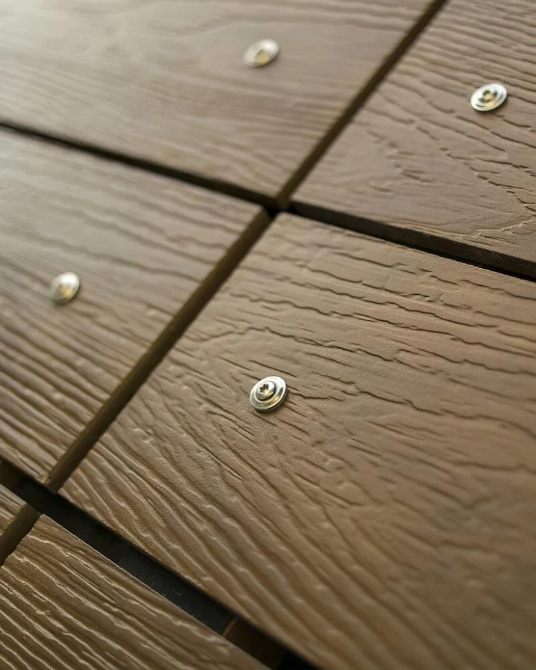 Detail dřevěného obkladu s viditelnými šrouby a texturou.