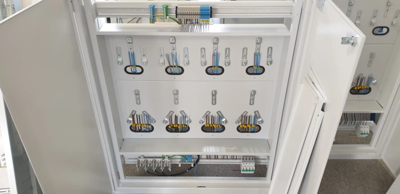 Vnitřní uspořádání elektrického rozvaděče s vodiči a jističi.
