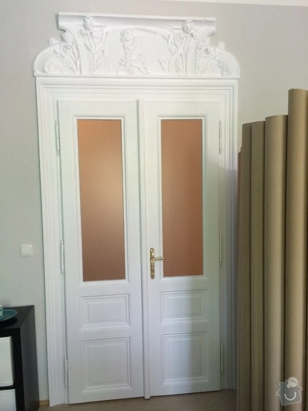 Bílé dvoudveřové dveře s výplněmi po renovaci v interiéru.