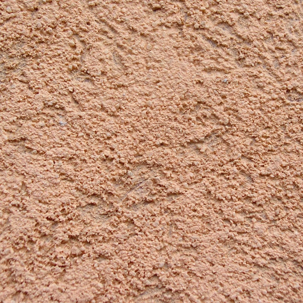 Detail texturované fasádní omítky s rýhovanou strukturou.
