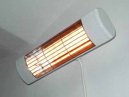Bílý elektrický přímotop s hořícími infračervenými prvky na zdi.