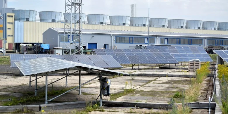 Fotovoltaické panely na střeše průmyslové budovy s optimálním sklonem.