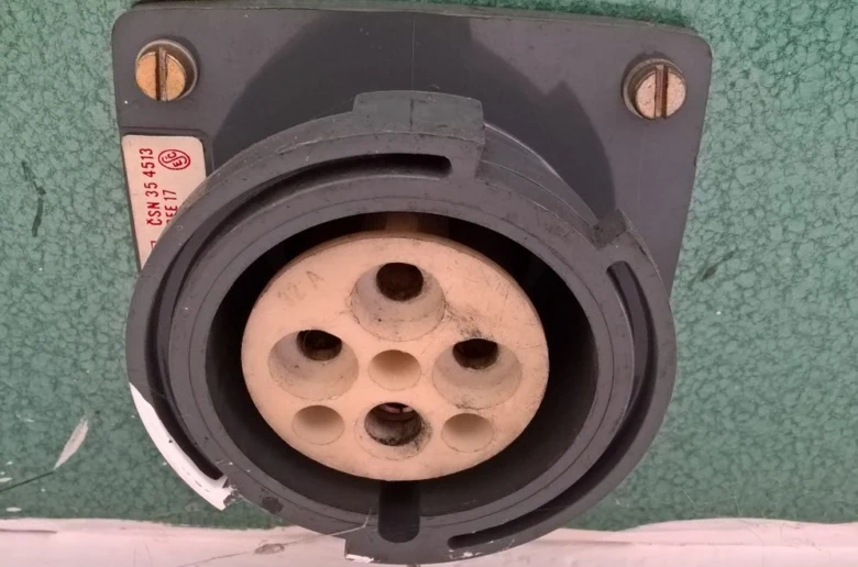 Průmyslový elektrický zástrčka s více kontakty pro domácí instalaci.