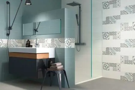 Moderní koupelna s bílými obklady zdobenými geometrickým vzorem.