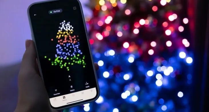 Smartfon s aplikací vánočního stromu před rozostřenými svátky