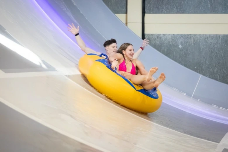 Dva lidé na žlutém nafukovacím prstenci v brněnském aquaparku.