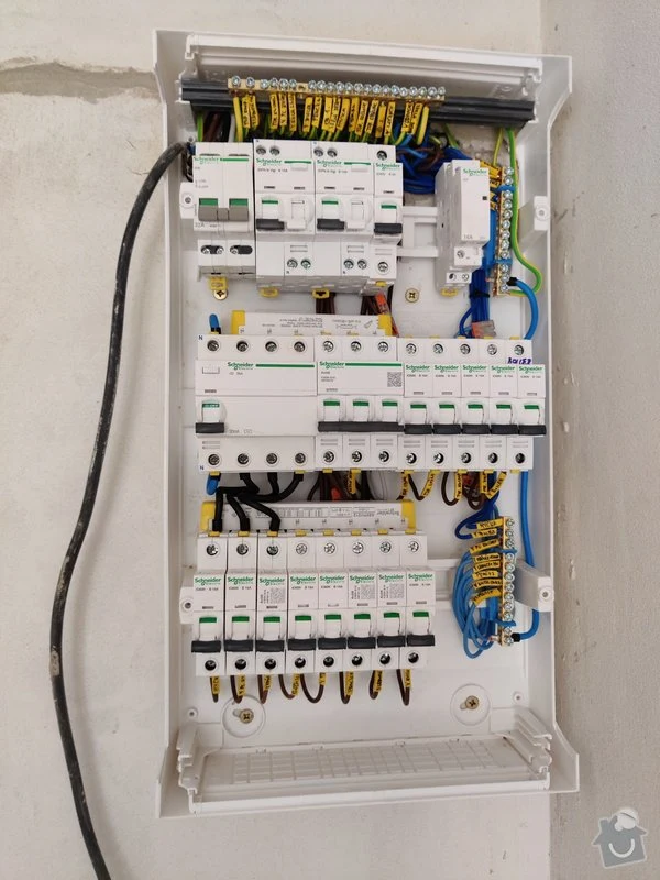 Otevřená elektrická rozvaděč s pojistkami a uspořádaným vedením.