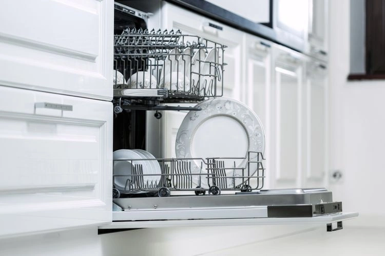 Otevřená vestavěná myčka nádobí s čistou bílou porcelánovou příborem.