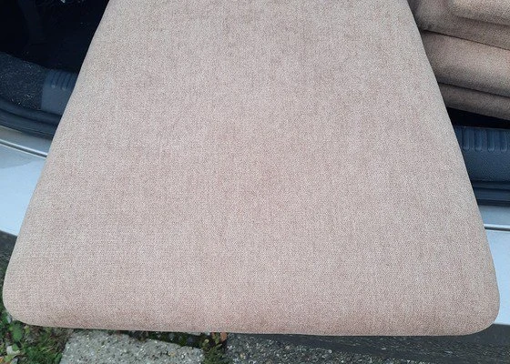 Blízký záběr na béžovou čalouněnou sedačku s viditelnou texturou látky.